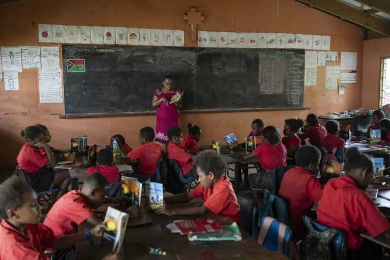 School children in Vanuatu read Safe Again, one of the books Save the Children is providing for children who experienced the massive earthquake